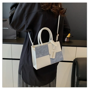 Dettaglio della borsa patchwork in pelle crema e tessuto di lana grigia mista