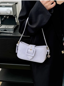 Detail of lavender purple baguette bag with large square buckle worn on a black blazer