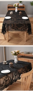 Detail of black lace tablecloth with elegant floral patterns and tassel fringe edges