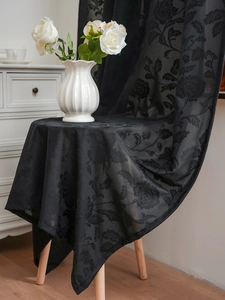 Close-up of black lace jacquard fabric with rose floral patterns and delicate texture
