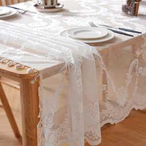 White French lace tablecloth with floral embroidery and elegant tassels on wood table