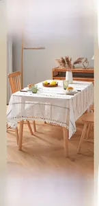 Detail of minimalist striped tablecloth with colorful mini pom-pom tassel fringe
