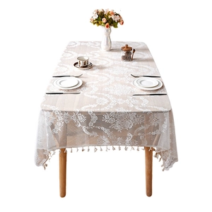 French lace tablecloth with elegant floral patterns and fringe on a wooden table