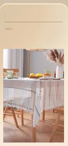 Detail of Nordic retro white tablecloth with colorful stripes and white pom-pom fringe