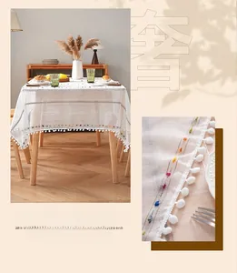 Close-up of semi-transparent white tablecloth with colorful stripes and fringe tassels