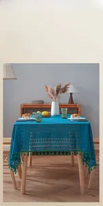 Detail of vintage peacock blue lace tablecloth featuring geometric hollow patterns and tassels