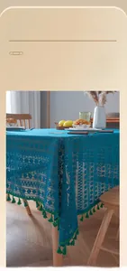 Detail of blue lace tablecloth featuring green tassel fringe and hollow-out vintage pattern