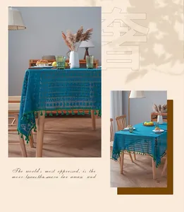 Blue crochet lace tablecloth detail with contrast green tassels and geometric patterns