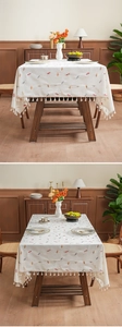 Detail of candy embroidery and fringe edge on cream rectangular tablecloth