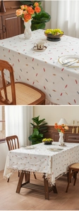 Detailed embroidery of colorful candies and fringe trim on a cream-colored thick tablecloth