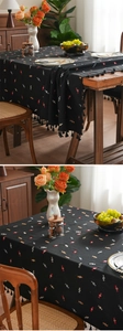 Detail of black cotton linen tablecloth with colorful candy patterns and elegant tassels