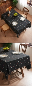 Close-up of black rectangular tablecloth with colorful candy prints and black tassels