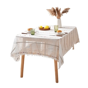 Minimalist beige rectangular tablecloth with colorful stripes and white ball pom-poms