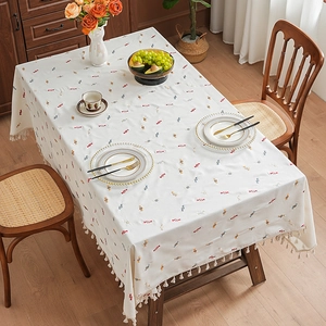 Colorful candy embroidered tablecloth with elegant tassels on a wooden dining table