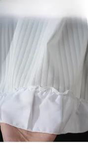 Detail of white pleated cafe curtain fabric with vertical stripes and ruffled edges