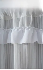Detail view of white ruffled cafe curtain with pleated texture and delicate sewing