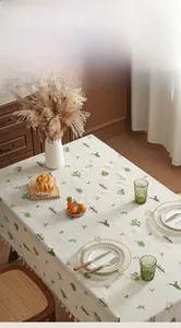 Close-up of linen tablecloth with green cactus embroidery and white tassel fringe edge