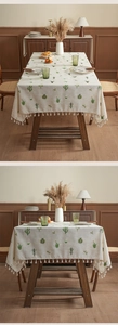 Close-up of linen tablecloth with cactus embroidery and tassel ball fringe detail