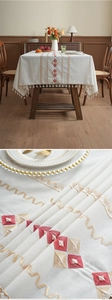 Close-up of geometric diamond embroidery and fringe tassels on bohemian tablecloth
