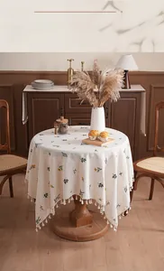Close-up of linen tablecloth with floral embroidery and white decorative tassels