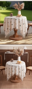 Detail of embroidered linen tablecloth with yellow floral patterns and fringed edges