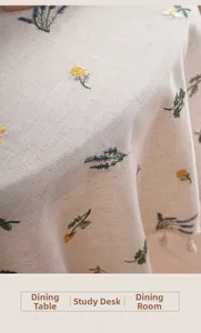 Detail of linen tablecloth with colorful flower embroidery and elegant tassel edges
