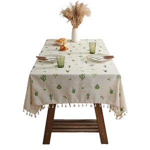 Linen tablecloth with cactus embroidery and tassel fringe on a wooden table