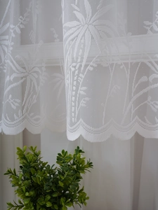 Gros plan du rideau de café en dentelle blanche avec motifs de feuilles et bord festonné