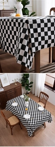 Detail of black and white checkerboard tablecloth showing cotton-linen texture and drape