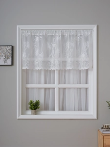 Détail de brise-bise en dentelle blanche avec broderie de palmiers et bord festonné