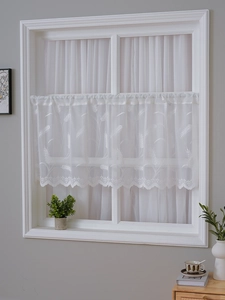 Detail of white lace cafe curtain featuring delicate wheat embroidery and scalloped edges