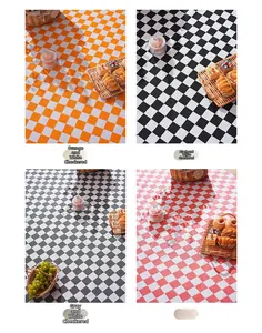 Detail view of plaid picnic blankets in orange, black, grey, and pink checkered patterns