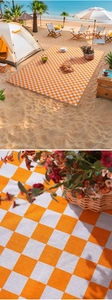 Detail of orange and white checkered picnic mat with premium woven fabric texture