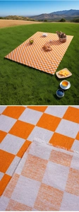 Macro detail of orange and white checkered picnic mat showing woven fabric and fringe