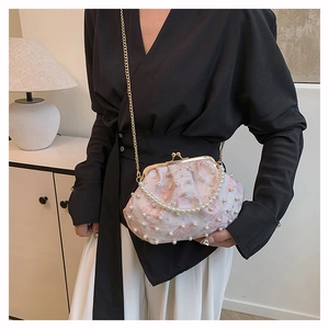 Detail of floral shell bag with pearl handle, gold metal clasp and chain strap