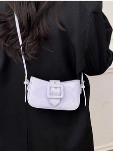 Detail of lavender purple leather underarm bag with large square buckle and gold hardware