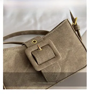 Close-up of khaki denim texture with oversized cloth buckle and gold hardware accents