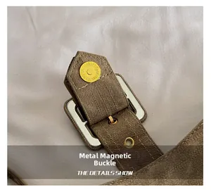 Detailed macro view of vintage brown canvas baguette bag with golden magnetic buckle
