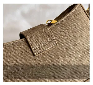 Detail of khaki brown canvas shoulder bag showing fine stitching and gold zipper hardware