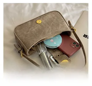 Detail showing internal capacity of khaki herringbone shoulder bag with gold hardware