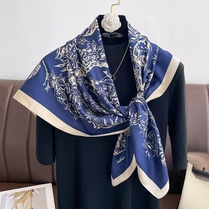 Elegant navy blue silk scarf with white floral patterns and cream contrast borders