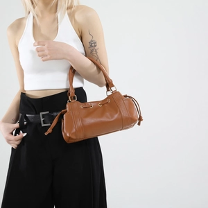 Brown vintage leather tote bag with drawstring detail and dual handles for women