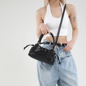 Fashionable black leather baguette bag with gold rings and adjustable straps for women