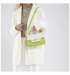 Detail of green and beige patchwork crossbody bag with gold metal lock closure