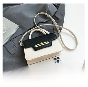 Detail view of contrast color crossbody bag showing interior capacity and gold metal buckle