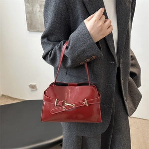Borsa a mano vintage in pelle bordeaux con fibbia metallica mostrata in uno scatto moda