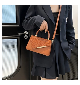 Borsa a tracolla marrone con motivo coccodrillo e fibbia in metallo dorato su modella