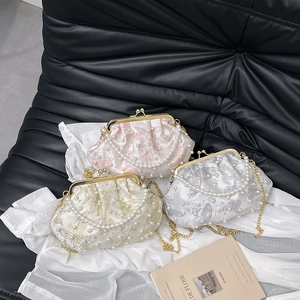 Elegant shell bags with pearl accents and floral embroidery on gold chain straps