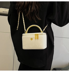 Close-up of white snake pattern crossbody bag with gold metal handle and floral detail