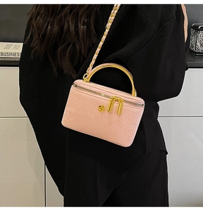 Detailed view of pink chain crossbody bag with golden flower accent and metal handle